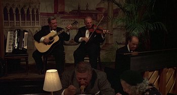 Movie still from “The Brink's Job” (1978), directed by William Friedkin – A group of men in suits and ties playing music; Wide shot, High angle