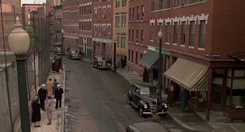 Movie still from “The Brink's Job” (1978), directed by William Friedkin – An old car parked on the side of the street; Extreme Wide shot, High angle