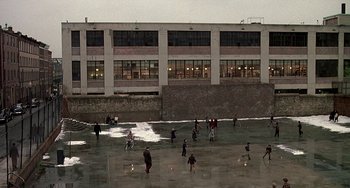 Movie still from “The Brink's Job” (1978), directed by William Friedkin – A group of people standing on top of a sandy beach; Extreme Wide shot, High angle