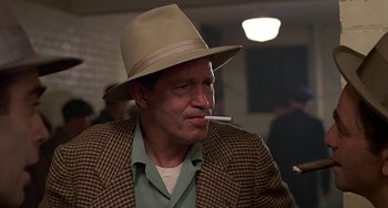 Movie still from “The Brink's Job” (1978), directed by William Friedkin – A man with a hat and a cigarette in his mouth; Close Up shot, Low angle