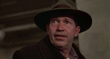 Movie still from “The Brink's Job” (1978), directed by William Friedkin – A person wearing a hat; Close Up shot, Low angle