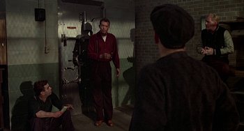 Movie still from “The Brink's Job” (1978), directed by William Friedkin – A group of men standing in front of each other; Wide shot, Over the shoulder angle