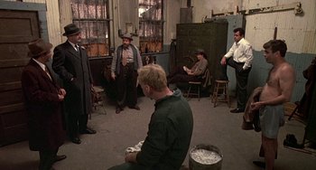 Movie still from “The Brink's Job” (1978), directed by William Friedkin – A group of men standing in a room; Wide shot, High angle