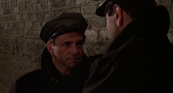 Movie still from “The Brink's Job” (1978), directed by William Friedkin – A man wearing a hat looking at another man in a hat; Close Up shot, Over the shoulder angle