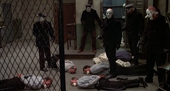 Movie still from “The Brink's Job” (1978), directed by William Friedkin – A group of people in masks laying on the ground; Wide shot, High angle