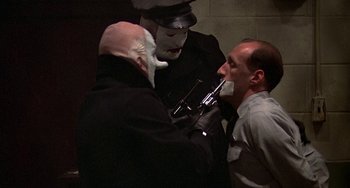 Movie still from “The Brink's Job” (1978), directed by William Friedkin – A man with a gun being held up by two men; Close Up shot, Over the shoulder angle