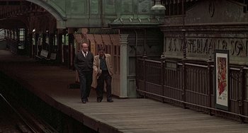 Movie still from “The Brink's Job” (1978), directed by William Friedkin – Two men in suits and ties walking down a pier; Wide shot, High angle