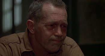 Movie still from “The Brink's Job” (1978), directed by William Friedkin – A person wearing a brown shirt; Close Up shot, Over the shoulder angle