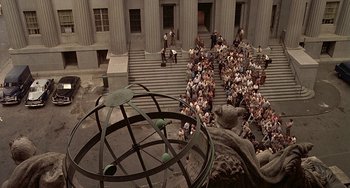 Movie still from “The Brink's Job” (1978), directed by William Friedkin – An overhead view of a crowd of people in front of a building; Extreme Wide shot, Overhead angle