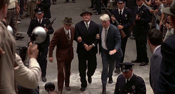 Movie still from “The Brink's Job” (1978), directed by William Friedkin – A group of men walking down a street holding guns; Wide shot, High angle
