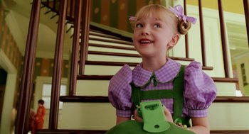 Movie still from “The Cat in the Hat” (2003), directed by Bo Welch – A little girl sitting on the stairs holding a cell phone; Close Up shot, High angle