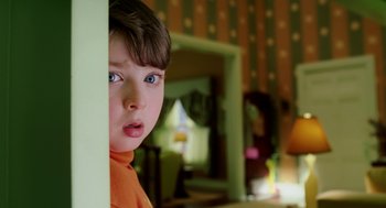 Movie still from “The Cat in the Hat” (2003), directed by Bo Welch – A little boy with blue eyes looking at the camera; Close Up shot, Over the shoulder angle