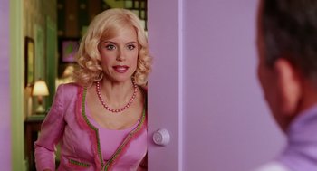 Movie still from “The Cat in the Hat” (2003), directed by Bo Welch – A woman in a pink dress peeks out from behind a door; Medium shot, Over the shoulder angle