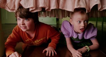 Movie still from “The Cat in the Hat” (2003), directed by Bo Welch – Two children are under a bed looking surprised; Medium shot, High angle