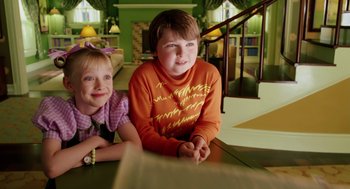 Movie still from “The Cat in the Hat” (2003), directed by Bo Welch – Two young children sitting at a table in a living room; Medium shot, Low angle
