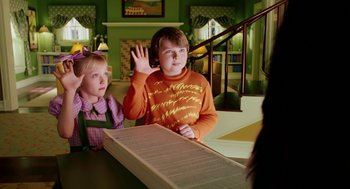 Movie still from “The Cat in the Hat” (2003), directed by Bo Welch – Two young children sitting at a table in a room; Medium shot, Over the shoulder angle