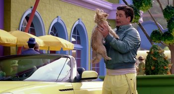 Movie still from “The Cat in the Hat” (2003), directed by Bo Welch – A man holding a dog in front of a yellow car; Medium shot, Over the shoulder angle