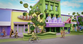 Movie still from “The Cat in the Hat” (2003), directed by Bo Welch – A sculpture of a person riding a bike in front of a building; Extreme Wide shot, Low angle