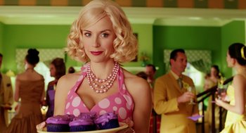 Movie still from “The Cat in the Hat” (2003), directed by Bo Welch – A woman holding a tray of cupcakes wearing a pink polka dot dress; Close Up shot, Over the shoulder angle