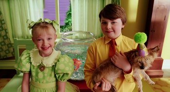 Movie still from “The Cat in the Hat” (2003), directed by Bo Welch – Two children are posing for a picture in front of a fish tank; Medium shot, High angle