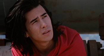 A man with long black hair wearing a red shirt