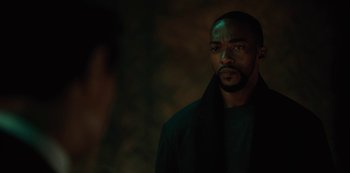 Movie still from “Altered Carbon” (2018), created by Laeta Kalogridis – A man in a black jacket standing in front of a wall; Close Up shot, Over the shoulder angle
