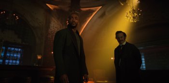 Movie still from “Altered Carbon” (2018), created by Laeta Kalogridis – Two men in suits standing in front of a wall; Medium shot, Low angle