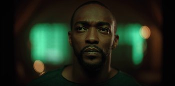 Movie still from “Altered Carbon” (2018), created by Laeta Kalogridis – A man's face in front of green lights; Close Up shot, Low angle