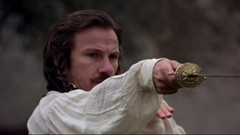 Movie still from “The Duellists” (1977), directed by Ridley Scott – A man in a white shirt is holding a sword; Close Up shot, Low angle