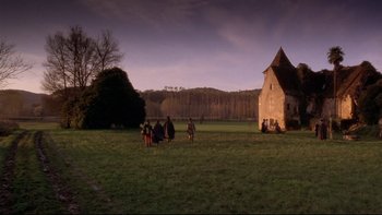 Movie still from “The Duellists” (1977), directed by Ridley Scott – A group of people standing on top of a lush green field; Extreme Wide shot, Low angle