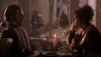 Movie still from “The Duellists” (1977), directed by Ridley Scott – A man and a woman sitting at a dinner table; Medium shot, Over the shoulder angle