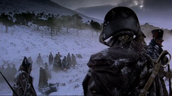 Movie still from “The Duellists” (1977), directed by Ridley Scott – A group of people standing in the snow near a hill; Wide shot, Over the shoulder angle