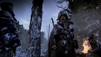 Movie still from “The Duellists” (1977), directed by Ridley Scott – A man standing next to a tree in the snow; Wide shot, Low angle