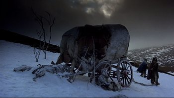 Movie still from “The Duellists” (1977), directed by Ridley Scott – A covered wagon sitting on top of a snow covered field; Wide shot, Low angle