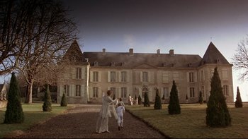 Movie still from “The Duellists” (1977), directed by Ridley Scott – A couple of people are walking in front of a building; Extreme Wide shot, Low angle