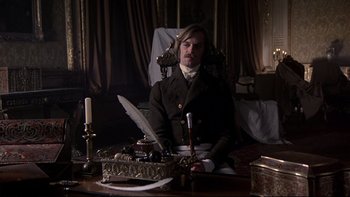 Movie still from “The Duellists” (1977), directed by Ridley Scott – A man sitting at a table with a feather quill pen; Medium shot, Low angle