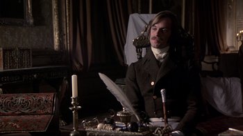 Movie still from “The Duellists” (1977), directed by Ridley Scott – A man sitting at a table with a feather quill pen; Medium shot, High angle