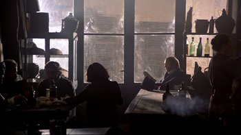 Movie still from “The Duellists” (1977), directed by Ridley Scott – A group of people sitting at a table in front of a window; Wide shot, Over the shoulder angle