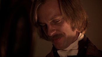 Movie still from “The Duellists” (1977), directed by Ridley Scott – A person wearing a suit and tie; Close Up shot, Over the shoulder angle