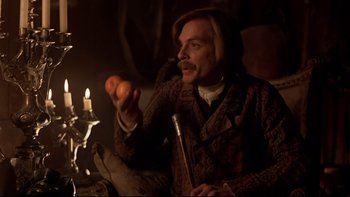 Movie still from “The Duellists” (1977), directed by Ridley Scott – A man holding an orange in his right hand; Medium shot, Over the shoulder angle
