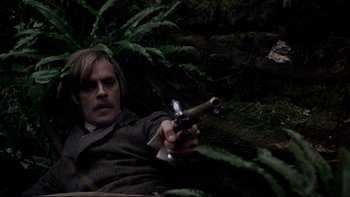 Movie still from “The Duellists” (1977), directed by Ridley Scott – A man holding a gun while laying on the ground; Medium shot, High angle