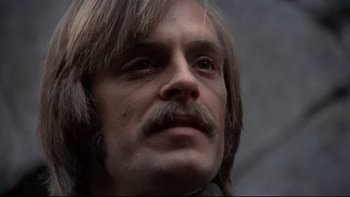 Movie still from “The Duellists” (1977), directed by Ridley Scott – A person with long hair and a mustache; Close Up shot, Low angle