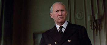 Movie still from “The Eagle Has Landed” (1976), directed by John Sturges – An older man wearing a suit and tie; Close Up shot, Low angle