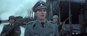 Movie still from “The Eagle Has Landed” (1976), directed by John Sturges – A man in a military uniform is looking at the camera; Close Up shot, Low angle