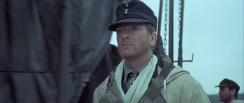 Movie still from “The Eagle Has Landed” (1976), directed by John Sturges – A person wearing a hat and a uniform; Close Up shot, Low angle