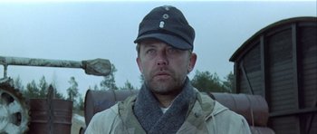Movie still from “The Eagle Has Landed” (1976), directed by John Sturges – A person wearing a hat and a scarf; Close Up shot, Low angle