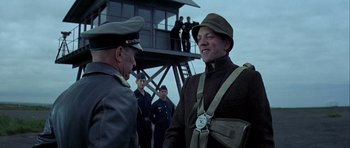 Movie still from “The Eagle Has Landed” (1976), directed by John Sturges – Two men in uniforms are talking to each other; Medium shot, Low angle