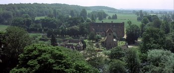 Movie still from “The Eagle Has Landed” (1976), directed by John Sturges – An aerial view of an english countryside with a church and trees; Extreme Wide shot, High angle