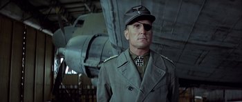 Movie still from “The Eagle Has Landed” (1976), directed by John Sturges – A man in a military uniform with a hat on; Close Up shot, Low angle
