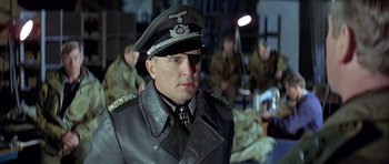 Movie still from “The Eagle Has Landed” (1976), directed by John Sturges – A man in a military uniform is looking to his left; Close Up shot, Low angle